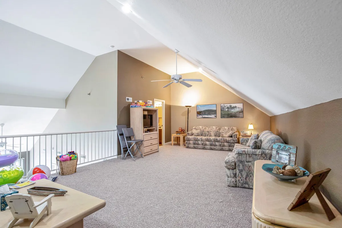 A cozy interior shot featuring a comfortable sofa, entertainment center, table, and wall pictures. The space is arranged for family gatherings, with plenty of room for playing games, watching movies, or relaxing together. The furniture and layout suggest a welcoming, kid-friendly environment.